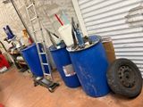 trois fûts bleus et une roue dans un garage