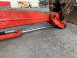 a close up of a large red pipe cutter on the ground