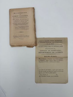 un vieux livre posé sur une table blanche, à côté d'une feuille de papier