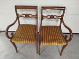 a pair of antique chairs with striped upholstered seats