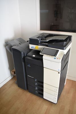 a black and white printer sitting on top of a wooden floor