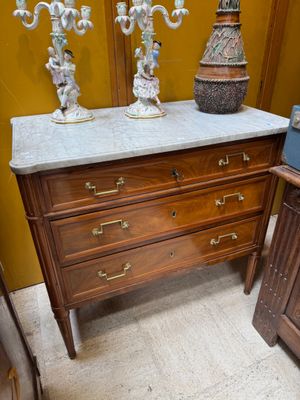 a marble top dresser in a room with a yellow wall