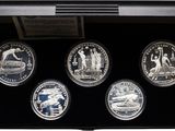 four silver coins in a display case with a black background