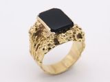 a gold ring with a black stone in the center