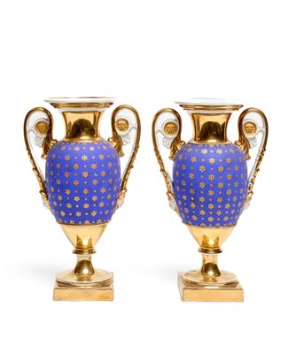 pair of blue and gold vases sitting on top of each other