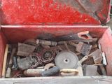 une boîte à outils rouge remplie d'outils, posée par terre