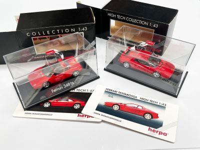 trois modèles réduits Ferrari rouges moulés sous pression, présentés dans des vitrines posées sur un fond blanc