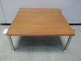 a wooden coffee table with metal legs on a tile floor