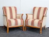 pair of striped upholstered chairs in a room with a white wall