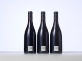 three bottles of wine sitting on top of a table next to each other