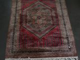 rug on the floor in a room with a chair and a table