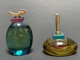 two perfume bottles with a bird on top of them