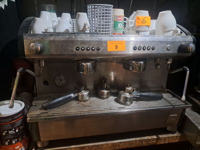 une image représentant une machine à café sur laquelle sont posées des tasses