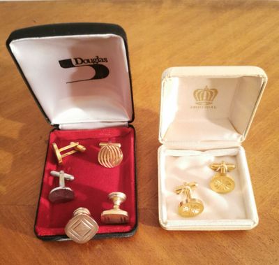 two pairs of cufflinks in a box on a table