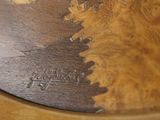 a close up of a clock on a wooden table