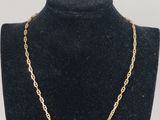 a gold chain necklace on a mannequin neck