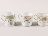 three coffee cups are lined up in a row on a white surface