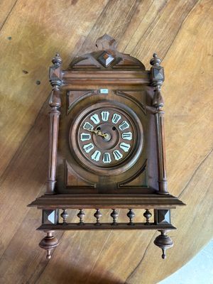 une horloge accrochée au mur et posée par terre