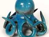 une pieuvre en céramique bleue posée sur une surface blanche