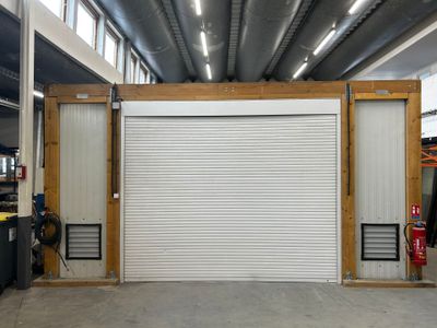 a garage with a garage door open and a fire extinguisher in the background