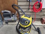 un aspirateur jaune et noir posé sur un sol en béton
