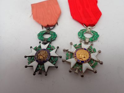 two medals and a red ribbon on a white surface