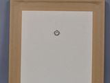 an empty picture frame sitting on top of a table next to a wall