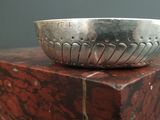 a silver bowl sitting on top of a red marble block
