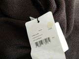 a label on a brown sweater that is hanging on a hanger