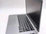 a silver laptop computer sitting on top of a white table