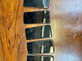 Plusieurs téléphones portables sont alignés sur une table en bois