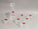 six verres et une carafe posés sur une table