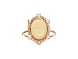 une bague en or sertie d'une pierre ovale entourée de petits diamants blancs