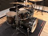 a drum set up in a recording room with a sound wall