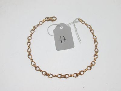 un gros plan sur un bracelet en chaîne dorée muni d'une étiquette de prix