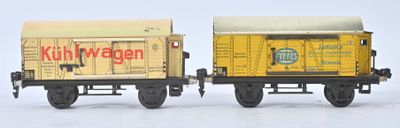 deux petits trains miniatures posés côte à côte sur une surface blanche