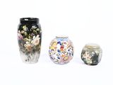 trois vases posés l'un à côté de l'autre sur une surface blanche