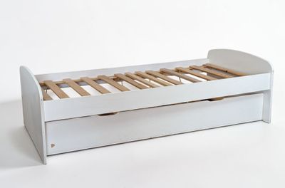 un lit blanc à lattes en bois, avec un tiroir en dessous
