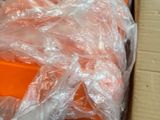 une caisse d'oranges emballée dans du plastique, posée par terre