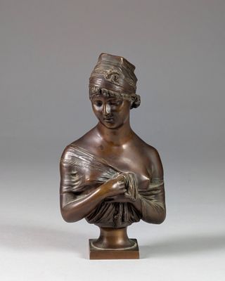 a bronze statue of a woman with a hat on her head