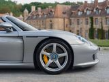 a silver sports car parked in front of a castle