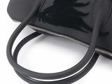 black leather handbag on white background with black strap