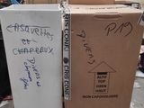 deux cartons posés sur une palette, sur lesquels figurent des inscriptions