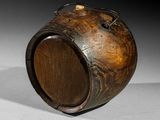 a wooden container with a handle on a white surface