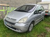 une voiture argentée garée à côté d'une remorque dans l'herbe