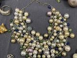 many different types of pearls and chains on a table
