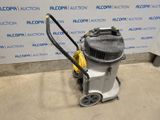 the vacuum is sitting on the floor in front of the wall