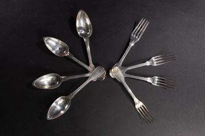 plusieurs cuillères et fourchettes disposées en cercle sur une surface noire
