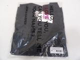 a black t - shirt in a plastic bag on a white table