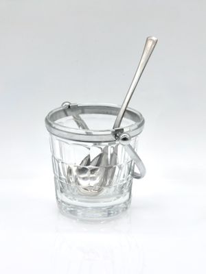 a glass cup with a spoon in it on a white surface